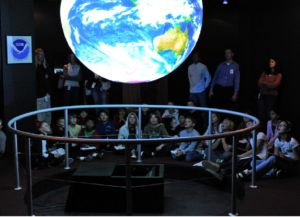 Image of children observing a glowing globe of the Earth.