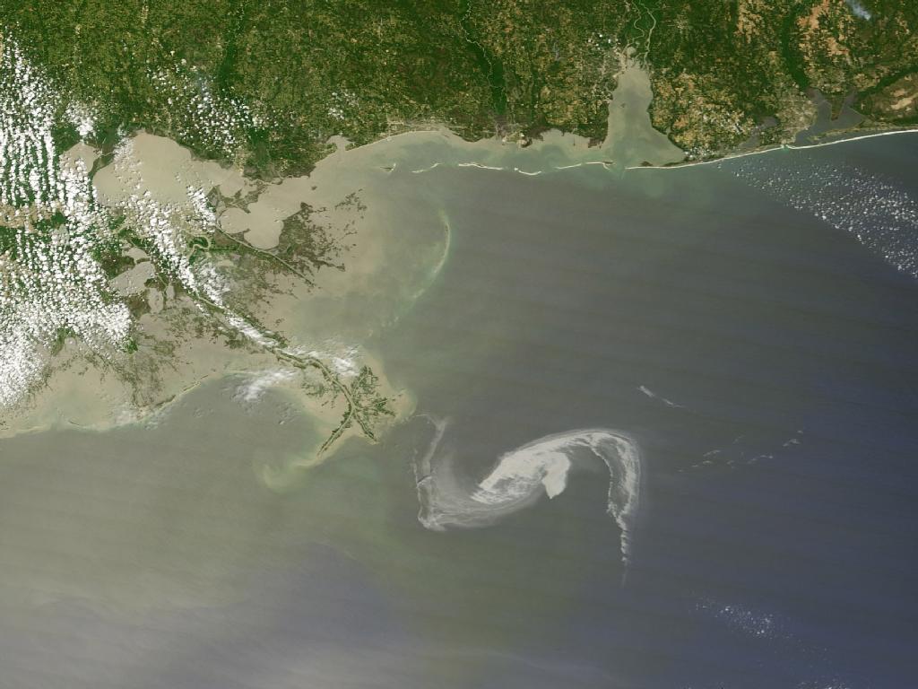 NASA Satellite Imagery Keeping Eye on the Gulf Oil Spill. On April 29, the MODIS image on the Terra satellite captured a wide-view natural-color image of the oil slick just off the Louisiana coast. The oil slick appears as dull gray interlocking comma shapes, one opaque and the other nearly transparent. Sunglint -- the mirror-like reflection of the sun off the water -- enhances the oil slick's visibility. The northwestern tip of the oil slick almost touches the Mississippi Delta.  Credit: NASA/Earth