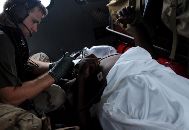 A U.S. Air Force airman provides medical assistance to an injured resident during search and rescue operations in Galveston, Texas, in September 2008 following the landfall of Hurricane Ike. Photo by U.S. Air Force. 