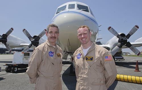 Picture of pilots Mike Singer and Shane Dover standing in front of the P-3B NASA aircraft at BWI. Image Source: NASA