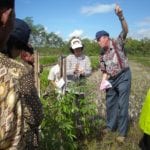Prof. Yunita T. Winarto (with rain gauge) and Prof. Kees Stigter discuss rainfall measurements with farmers from Wareng, Gunungkidul, Yogyakarta Special Province, Indonesia. Photo courtesy of authors.
