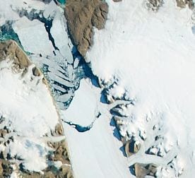 Satellite image of ice breaking off of the Petermann Glacier. Credit: NASA Earth OBservatory