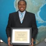 photo of Michael Joseph Williams holding the Award of Excellence for his research poster at the 2012 NASA Summer Intern Symposium. Image Credit: URC.