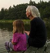 Image of a child and a woman sitting on a dock. (Image: Jan Håkan Dahlström/Plainpicture)