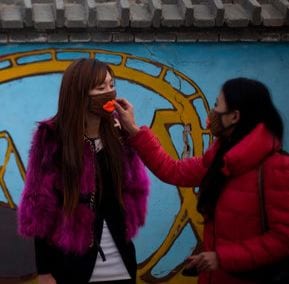 Image of two women wearing masks. Image: Alexander F. Yuan/Associated Press
