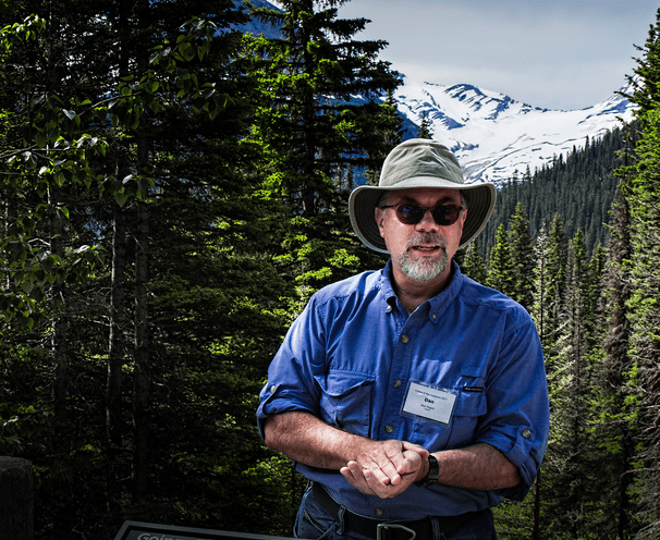 USGS research ecologist Dan Fagre in Glacier National Park, with Jackson Glacier in the background. Image Credit: Osha Gray Davidson.