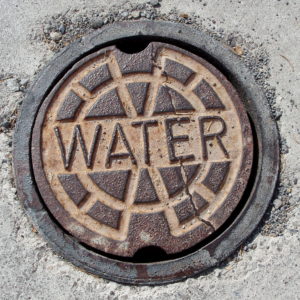 With the help of big data, old water meters like the one underneath this cover are starting to get a makeover. Image Credit: Teddy Page