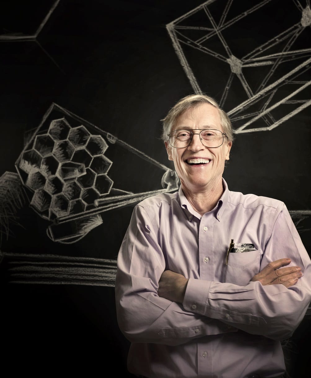 John Mather is excited about the release of the upcoming James Webb Space Telescope, sketched behind him, and how future discoveries in cosmology might benefit science as a whole. Image Credit: Chris Gunn