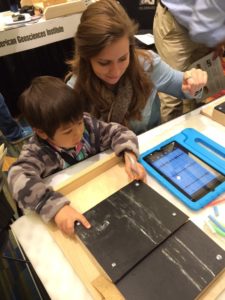 Katelyn Murtha, an AGI outreach associate, works with a student to understand how seismographs can detect motion in the Earth during Earth Science Week 2015. Image Credit: Katelyn Murtha/AGI