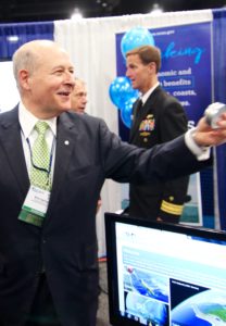 Dr. Richard (Rick) Spinrad laughing as he hands out M&M’S to the crowd at the unveiling of NOAA IOOS’s new logo at the MTS/IEEE OCEANS ’15 conference in Maryland. Image Credit: Jenny Woodman