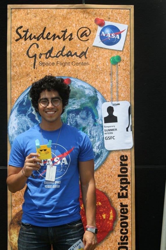 Physics student Frank Ceballos standing in front of a banner at Goddard SPace Center. Image Credit: URC.